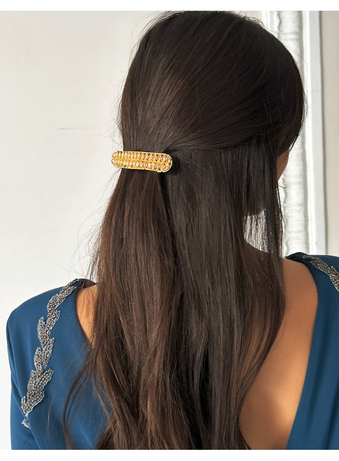 Golden barrette with pink crystals in the shape...