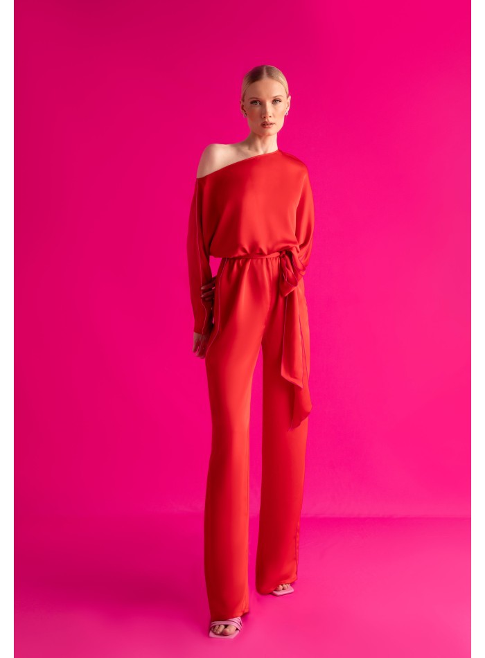 Asymmetric red jumpsuit with bat sleeves and belt