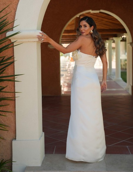 Longue robe blanche avec fente latérale et détails floraux