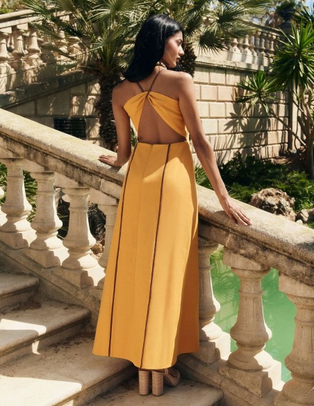 Vestido de invitada largo mostaza con caída fluida con espalda descubierta