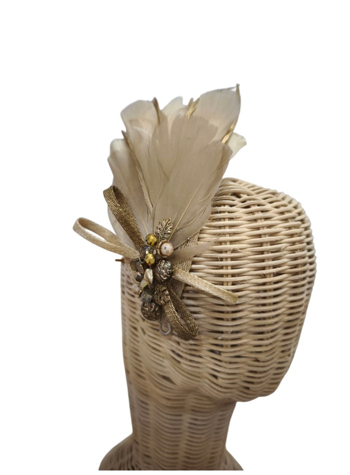 Tocado con plumas y pedrería en tonos beige para invitada