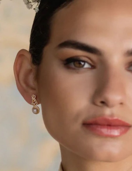 Boucles d'oreilles avec zircons entrelacés et perle centrale