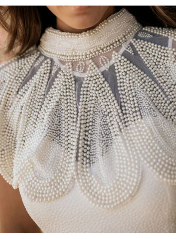 Collier blanc orné de perles et de motifs...