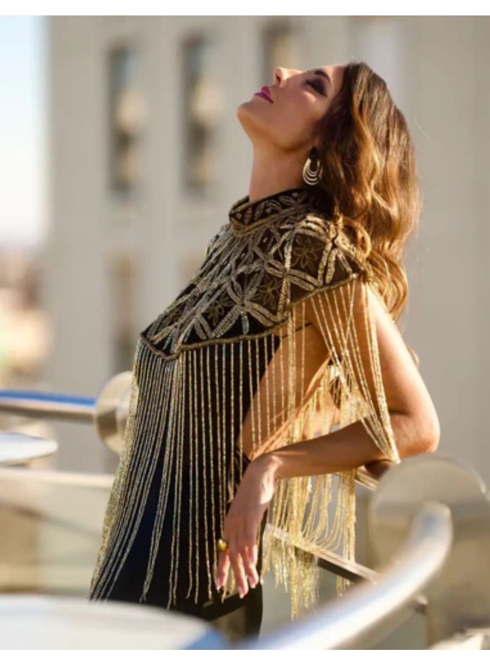 Cape ornée de bijoux, de broderies géométriques...