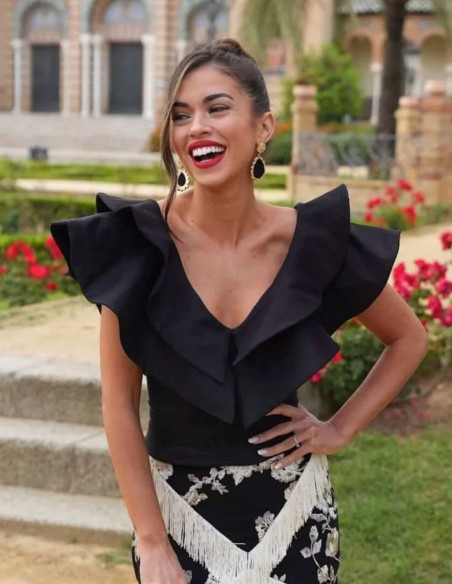 Black top with double ruffle V-neckline for guests