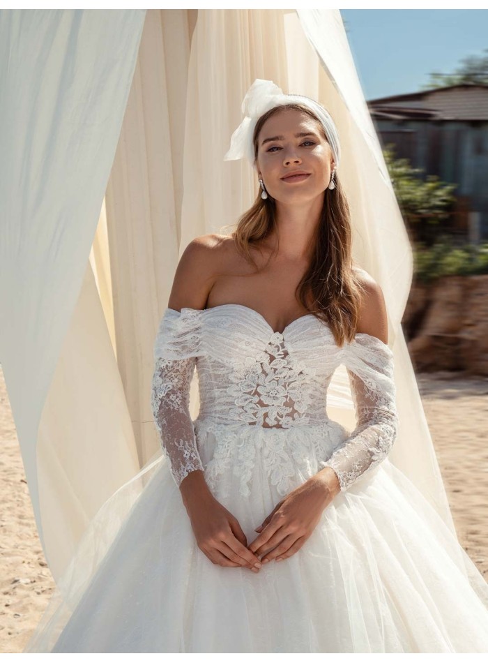 Princess cut wedding dress with wrap-around neckline and long sleeves in delicate lace at INVITADISIMA