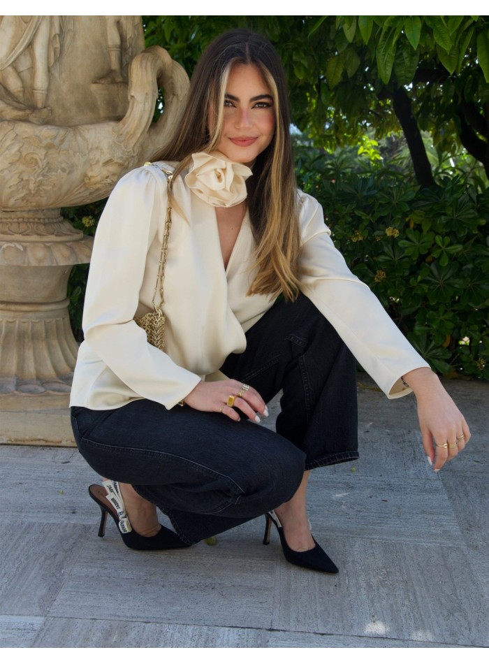Blusa de fiesta satinada con diseño cruzado y flor en el cuello de Elsa Barreto