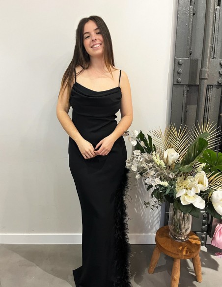 Long party dress with feathers in the opening.