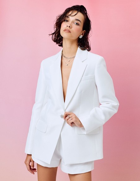Veste blanche de style blazer avec revers et boutons ornés de pierres précieuses