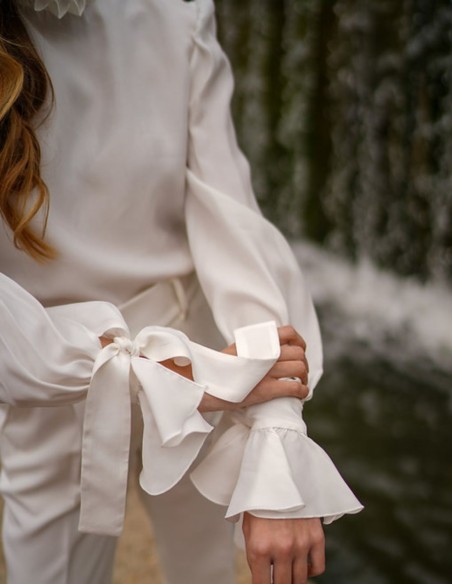 White blouse with long sleeves and ruffled details